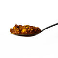 Spoon with a scoop of Green Juju's Lua Fermented Paste on a white background