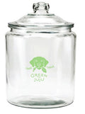 A clear glass dog treat  jar with a lid, featuring a green logo that reads 'Green Juju'